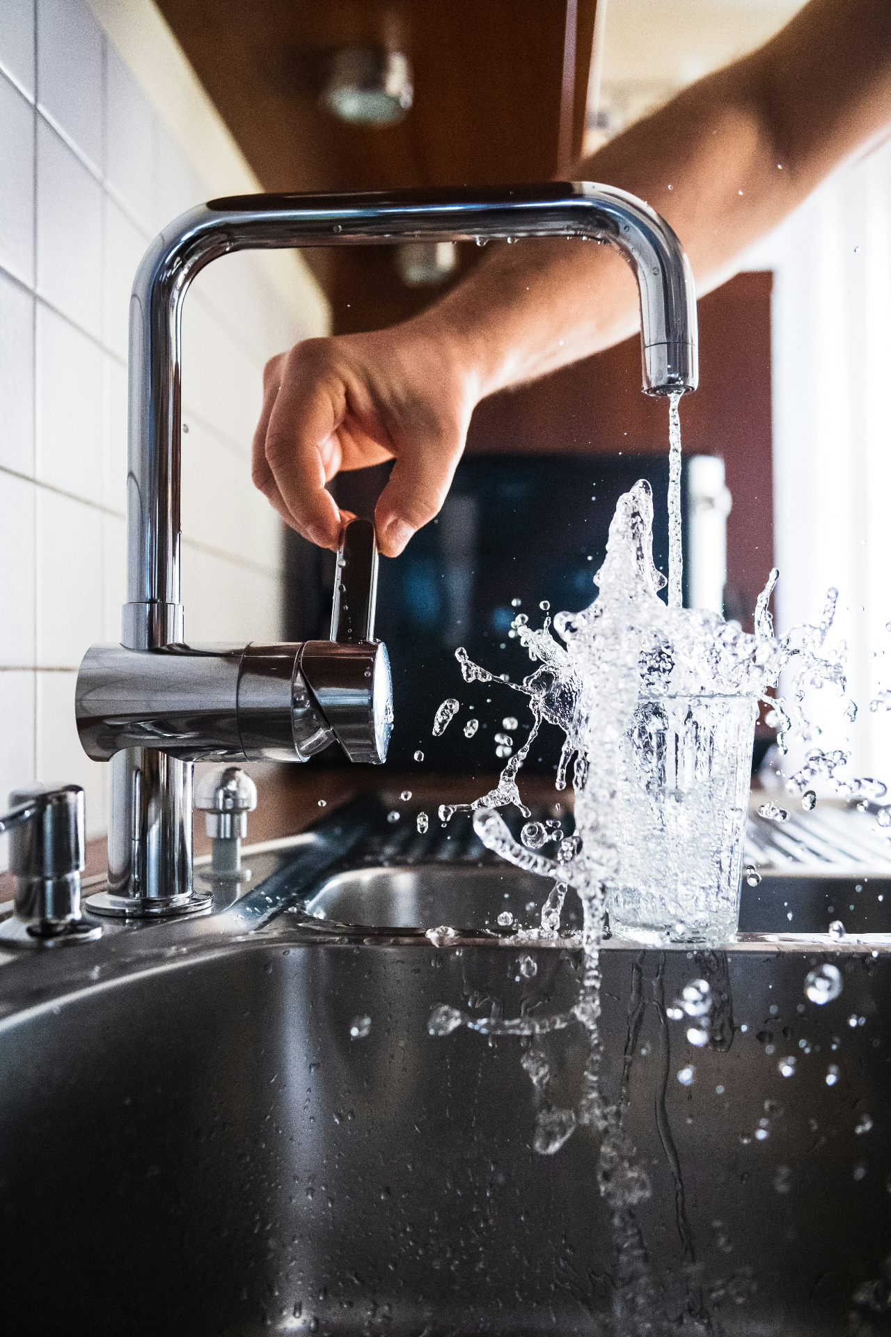 Chrome kitchen faucet with splashing water